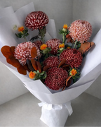 Bouquet of flowers wrapped in white paper on a light gray background