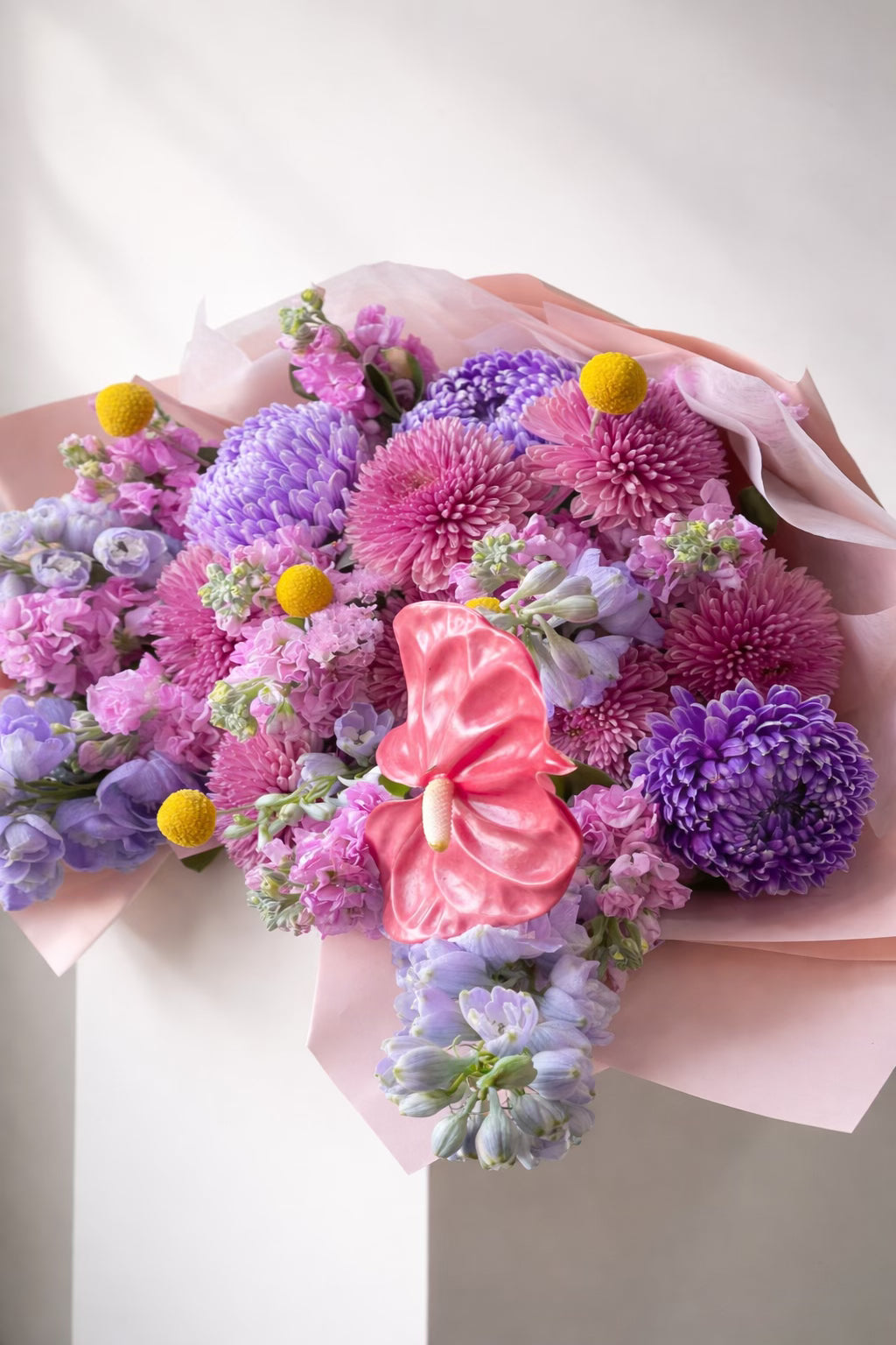Bouquet of colorful flowers with a pink bow on a white background